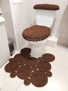 a white toilet sitting next to a pile of brown rugs on top of a bathroom floor