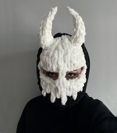 a person wearing a knitted mask with horns