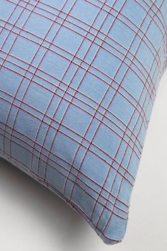 a blue and red plaid pillow sitting on top of a white table