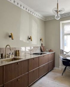 a large kitchen with wooden cabinets and marble counter tops, along with a dining room table