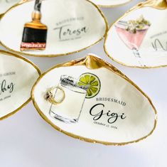 four personalized wedding coasters with cocktail glasses and rings on them, sitting on a white surface