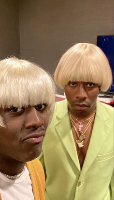 two men wearing wigs and one is looking at the camera