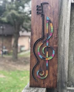 a wooden sign that has some beads on it