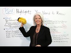 a woman standing in front of a whiteboard with writing on it