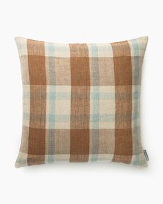 a brown and blue plaid pillow on a white background