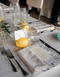 the table is set with silverware, lemons and napkins for dinner guests