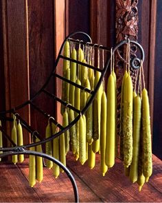 some yellow bananas hanging from a rack on a wooden table