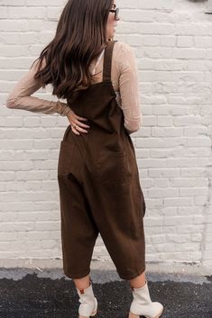 Step into effortless style with the Bridget Denim Overall Jumpsuit. Made from durable denim fabric, this jumpsuit features wide-leg pants and two front cargo pockets for a utilitarian touch. The square neckline and adjustable straps ensure a comfortable fit, while black drawstring details add a trendy, playful element. Available in cream or dark brown, the Bridget Jumpsuit is a versatile piece that can be dressed up or down for any occasion. Clear Purses, Overall Jumpsuit, Faux Leather Purse, White Bodycon Dress, Studded Necklace, Travel Dress, Faux Leather Belts, Jumpsuit Shorts Rompers, The Square