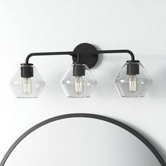 A smooth blend of rustic + industrial, this vanity light’s three glass shades showcase striking hexagonal silhouettes. It’s built from steel, and suitable for damp locations, like a bathroom. Install it with a dimmer switch to easily set the vibe in your space. AllModern Shade Color: Clear, Finish: Midnight Black AllModern Rooks 3 - Light Dimmable Vanity Light in Clear/Midnight Black | Size 10.25" H X 26" W X 8.5" D Industrial Farmhouse Lighting, Modern Vanity Lighting, Rental Kitchen, Powder Bath, Farmhouse Lighting, Modern Sculpture, Midnight Black, Vanity Light, Vanity Lighting