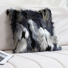 a black and white pillow sitting on top of a couch next to a photo frame