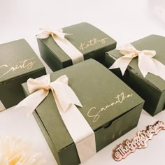 four green boxes with white bows and name tags