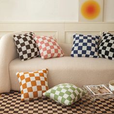 a living room with checkered pillows on the couch and coffee table next to it