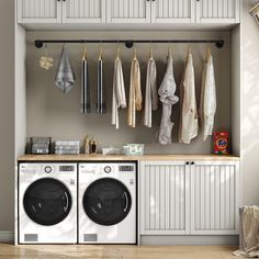 a washer and dryer sitting in front of a shelf with towels hanging on it