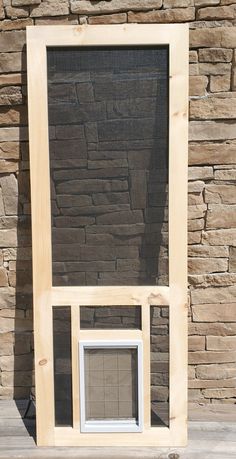 a wooden frame with a small window in front of a stone wall