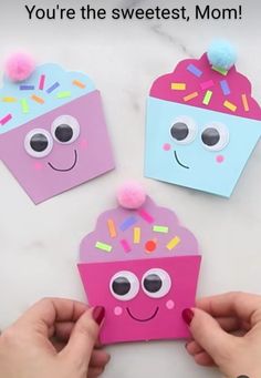 someone is holding up some paper cupcakes to make them look like they have eyes