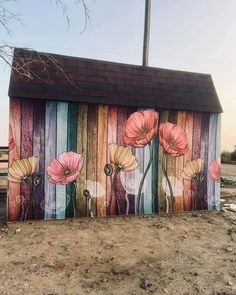 a painted wooden building with flowers on it