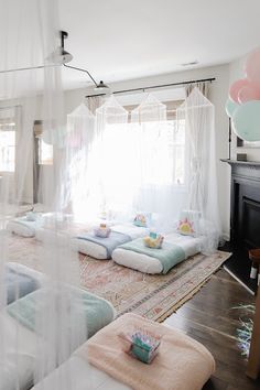 a living room filled with lots of white furniture and pillows on top of a rug