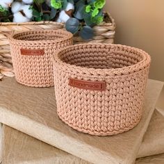 two crocheted baskets sitting on top of a table