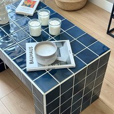 a blue tiled coffee table with magazines and glasses on it