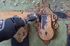 an electric drill is being used to fix a rusted door handle on a wall