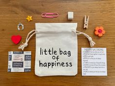 a little bag of happiness on a wooden table with paper clips, scissors and magnets