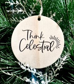 a wooden ornament hanging from a christmas tree with the words think celestial on it