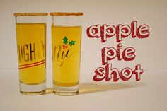 two glasses filled with apple pie shot sitting on top of a white table next to each other