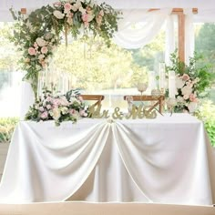 the table is covered with flowers and greenery