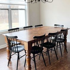 a dining room table with six chairs and a chandelier hanging from the ceiling