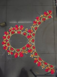 a pair of feet standing next to a table with red and gold designs on it