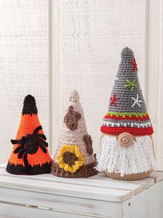 three crocheted gnome hats sitting on top of a white dresser