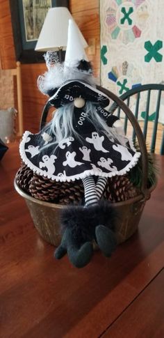 a basket filled with halloween decorations on top of a wooden table next to a lamp