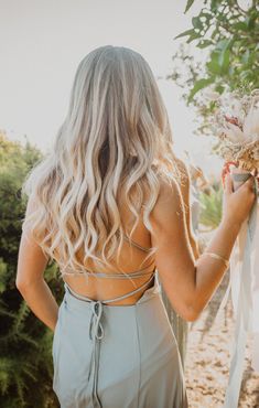 the back of a woman's dress holding flowers