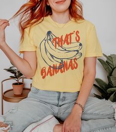 Go bananas for vintage style with our "That's Bananas" retro inspired graphic tee. We use professional quality DGT printing on all our apparel. Direct-to-garment, or DTG, is a high quality printing method that sprays ink directly onto the garment so there is no peeling or cracking. This fabulous graphic will be printed on a Comfort Colors Unisex T-Shirt. Please refer to the size charts in the images for the best fit.  Estimated Production Time: 1-5 days Estimated Shipping Time: 2-5 days 100% cot Relaxed Fit Graphic Tee With Vintage Print, Vintage Text Print T-shirt For Spring, Vintage Summer T-shirt With Funny Print, Summer Cotton T-shirt With Vintage Print, Vintage Cotton T-shirt For Summer, Fun Acid Wash Pre-shrunk T-shirt, Retro Graphic Print Crew Neck Top, Retro Crew Neck Top With Graphic Print, Retro Summer Tops With Letter Print