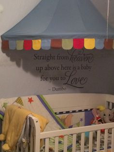 there is a baby crib in the corner with a wall decal above it