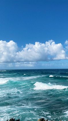 an ocean view with waves crashing on the rocks