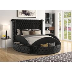 a bed with black headboard and foot board in a room next to a window