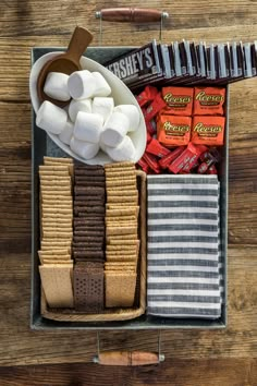 a box filled with candy and marshmallows on top of a wooden table