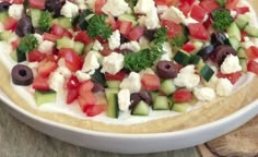 a bowl filled with cucumber, tomatoes, olives and feta cheese