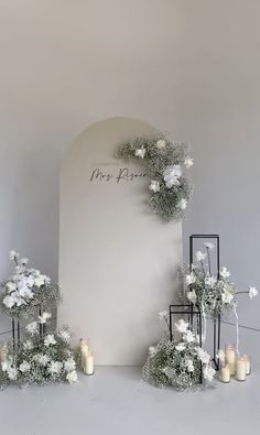 an arch decorated with white flowers and candles