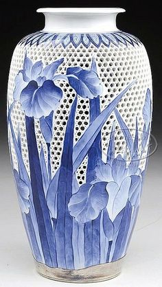 a blue and white vase with flowers painted on it