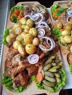 two trays filled with different types of food on top of each other, including meat and veggies