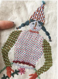 someone is stitching an embroidered ornament on a piece of cloth