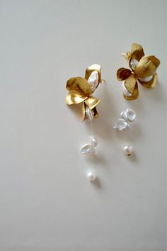 ⭐️⭐️⭐️⭐️⭐️ "I absolutely adore these gold pearl drop earrings! They are the perfect blend of elegance and simplicity, and they add a touch of sophistication to any outfit. The pearls have a beautiful luster and the gold setting is just stunning. I wore them to a wedding and received so many compliments. They are lightweight and comfortable to wear all day. I couldn't be happier with my purchase! Highly recommend!" - Olivia M. Bridal Jewelry Earrings, Elegant Dangle Earrings, Floral Pearl Earrings, Elegant Wedding Earrings, Elegant Handmade Flower Earrings, Elegant Bridal Earrings With Handmade Gold Flowers, Elegant Gold Bridal Earrings With Handmade Flowers, Gold Pearl Earrings With Flower Charm For Wedding, Elegant Handmade Flower Drop Bridal Earrings