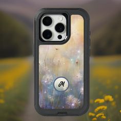 an iphone case with the letter m on it in front of a field full of dandelions