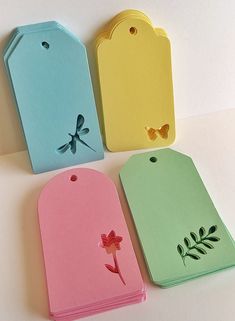 four tags with dragonflys on them are lined up in different colors and shapes