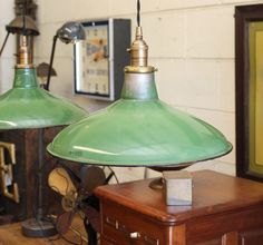 two green lamps sitting on top of a wooden table