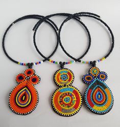 three colorful beaded necklaces on a white surface