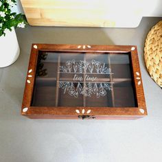 a wooden box with some writing on it sitting next to a basket and vases