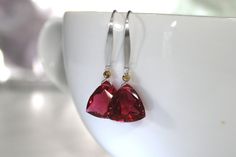 "Gorgeous red trillion of AAA quartz with a sparkle of warm gold for simply stunning earrings. Drops of pure, gorgeous red with just an ever so slight tinge of pink! So pretty and delicate and so luscious! Red ruby quartz in a trillion cut accented with a tiny gold hematite, so perfect for that simple touch of elegance. A sterling silver ear wire has been slightly hammered and finished into a modern, sleek contemporary earwire. These are perfect pops of gorgeous color! Quartz Trillions are 12mm Modern Red Earrings For Party, Modern Red Party Earrings, Red Faceted Earrings For Formal Occasions, Modern Red Teardrop Jewelry, Red Faceted Earrings For Anniversary, Red Faceted Drop Earrings, Red Faceted Dangle Earrings, Red Nickel-free Crystal Earrings, Red Gemstone Gold-plated Earrings